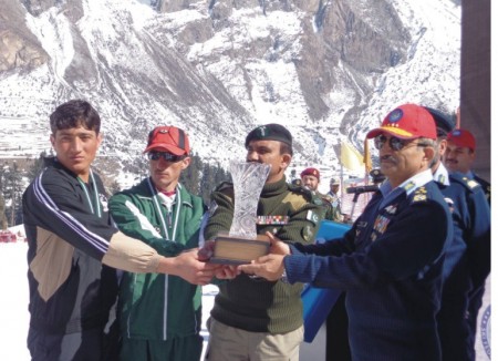 The Air Chief Marshal is handing over the winners' trophy to the Gilgit-Baltistan Scouts' team captain 
