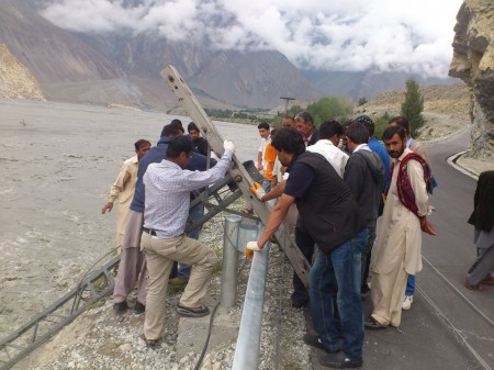 Local volunteers relocating the threatened electric poles: Photo Courtesy: Shah Wali