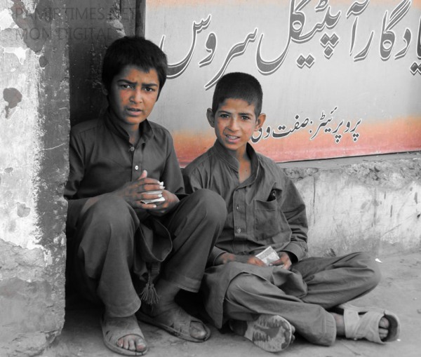 Two young kids counting money in the corner of a street in Gilgit. At this tender age the chances of young kids falling prey to social evils is very high. 