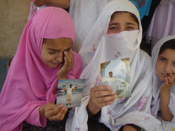 Children of the deceased holding the photographs of their dear ones 