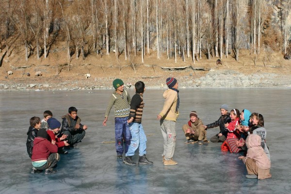 Children in large number run on the frozen surface, oblivious to the many risks involved 
