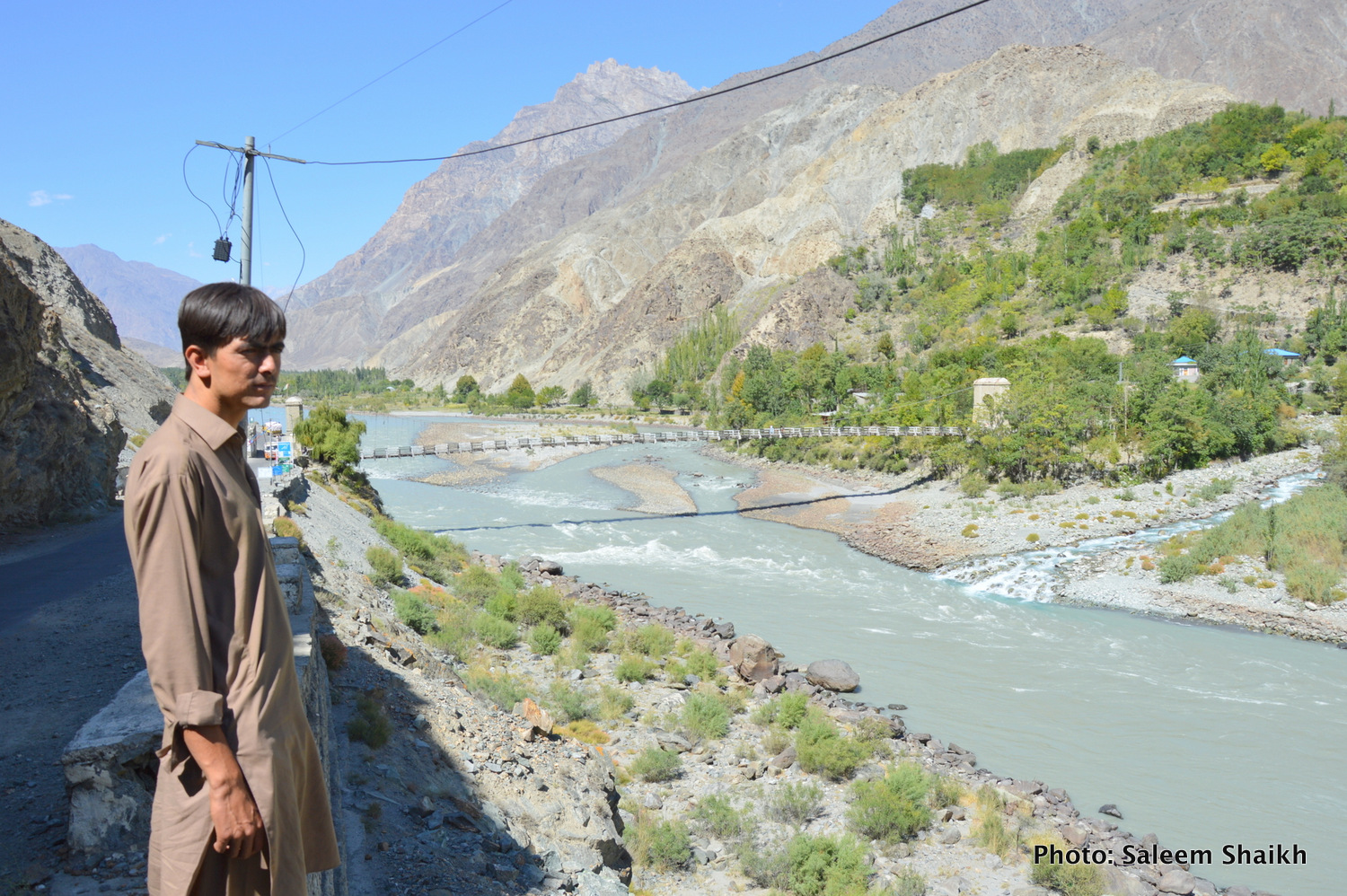 A boy looks at Gizer river, main tributary of the Indus river in picturesque valley of Gizer district, Pakistan’s north. The locals say the river often gets swollen and pose serious risk to different mountain communities on its either side as local temperature continue to rise, causing paced-up glacial melt which generates flash floods. Photo credit: Saleem Shaikh