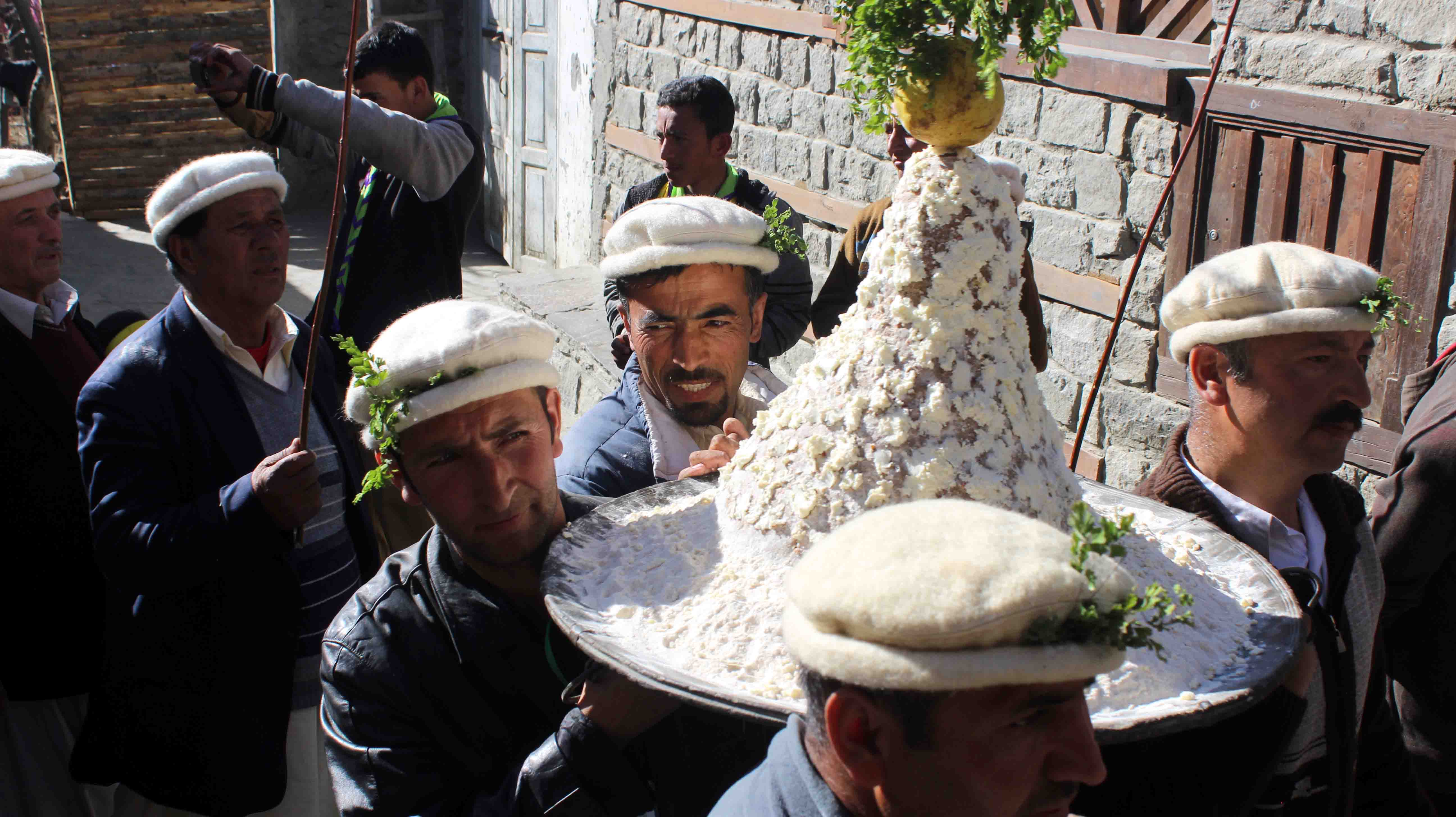 Locals carrying a traditional dish 